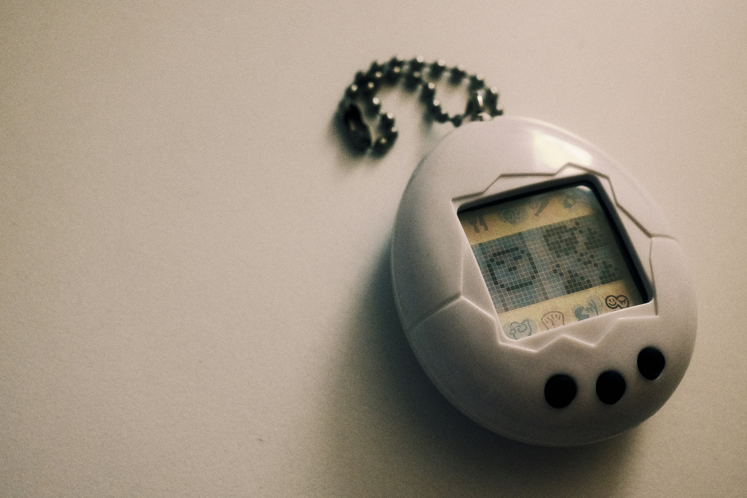 Harmaa Tamagotchi harmaalla taustalla