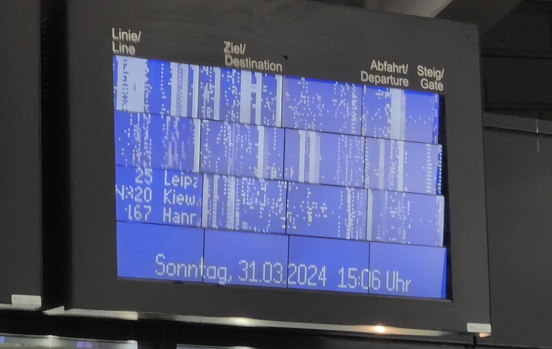 Kuva bussiterminaalin aikataulunäytöstä, jonka grafiikka on glitchannut.